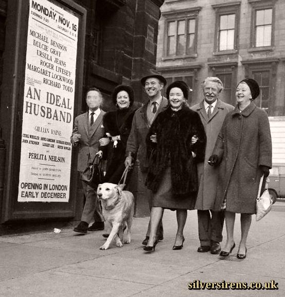 The cast from An Ideal Husband take the dog for a walk outside a theatre featuring a poster for their show.  Candid picture shows (L-R): Richard Todd (obscured by his cigarette smoke!), Margaret Lockwood, Michael Denison (with dog), Dulcie Gray, Roger Livesey and Ursula Jeans.  Glasgow, 1961.