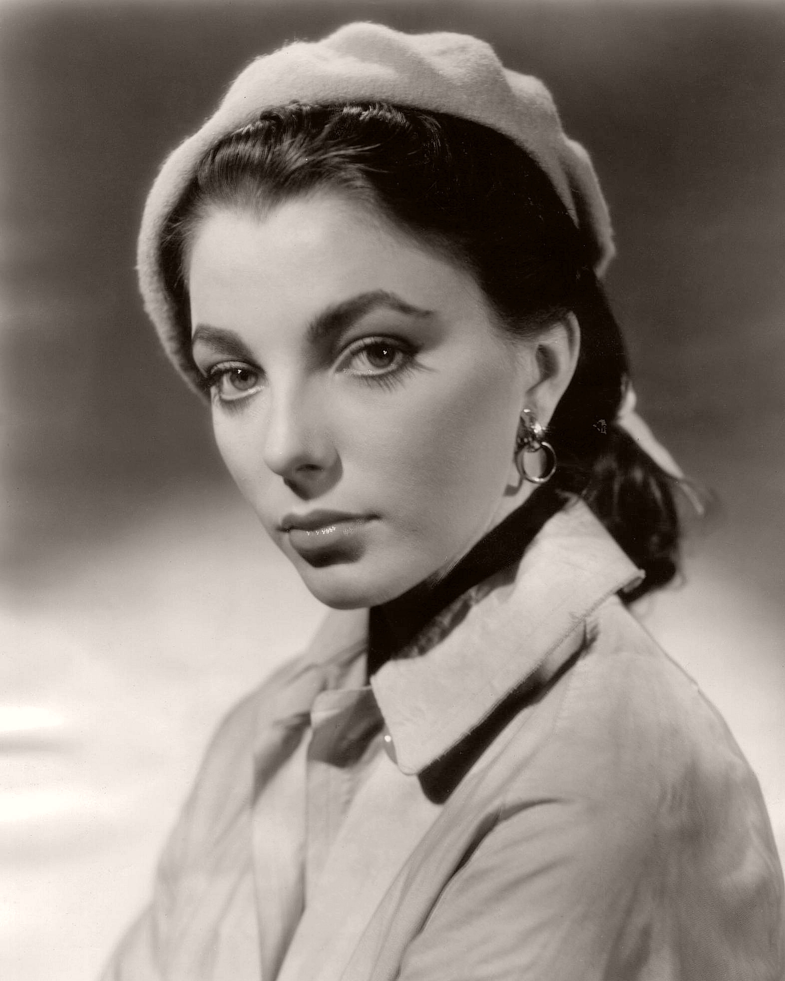 Photograph of Joan Collins from the 1950s. The English actress is sporting a beret