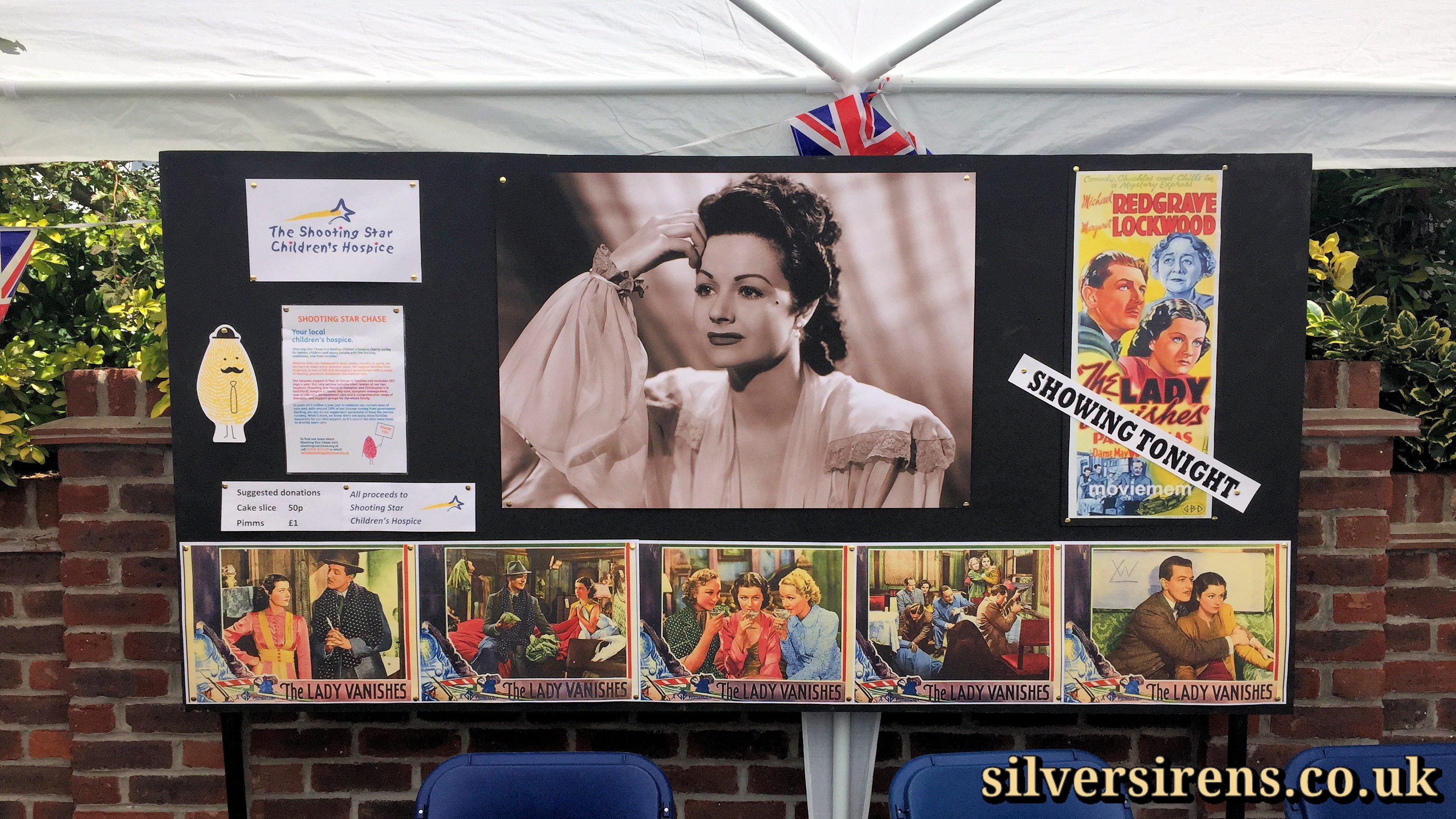 Margaret Lockwood plaque refreshment tent featuring posters for The Lady Vanishes and its screening.  Cake stall taking donations for The Shooting Star Children’s Hospice