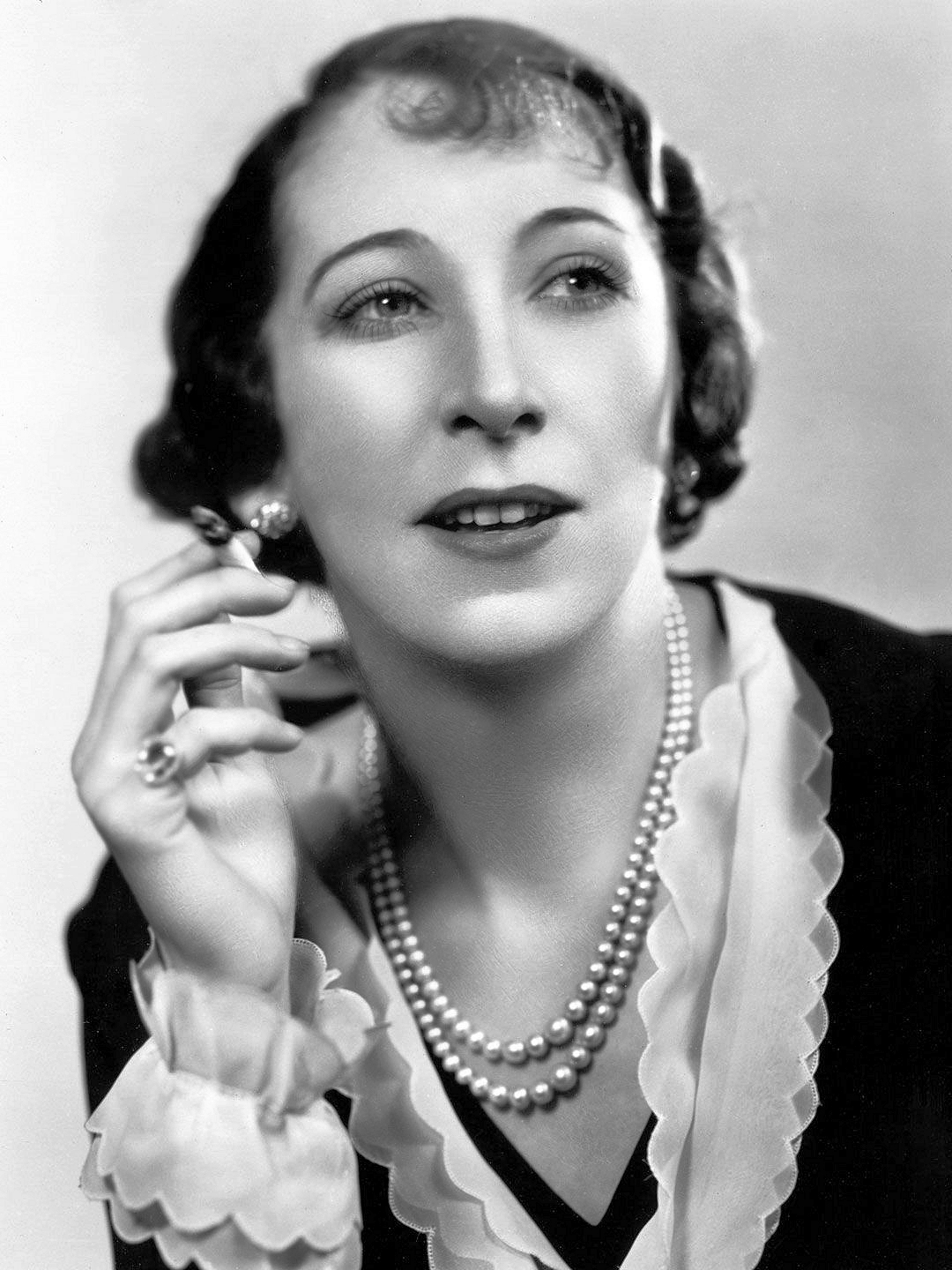 Photograph of British actress, Martita Hunt (1). The actress wears pearls while smoking a cigarette