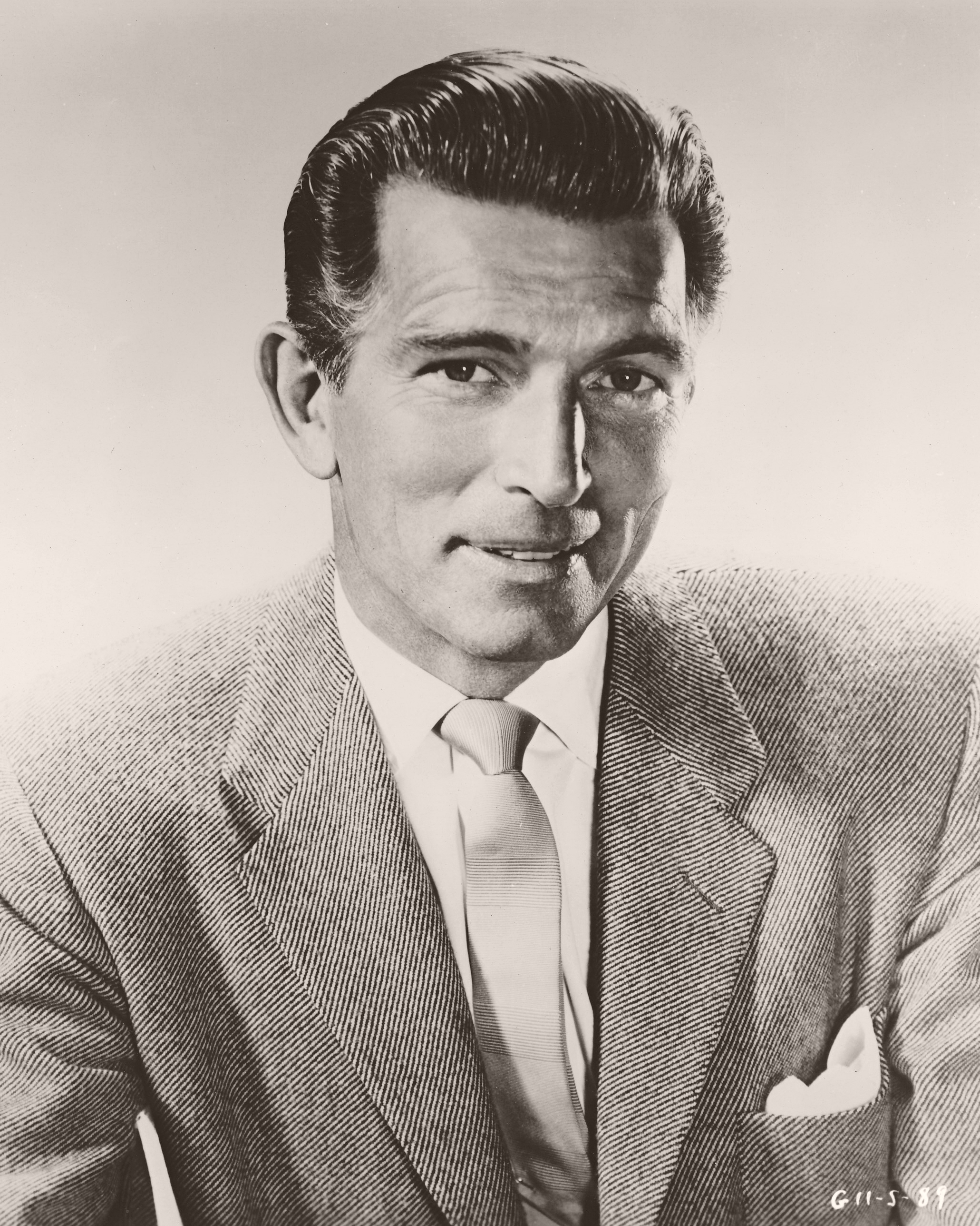 Photography of Michael Rennie, British actor, wearing a jacket and tie