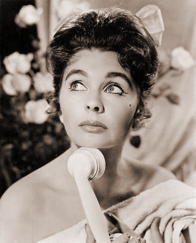 British actress Jean Simmons looks thoughtful as she holds the telephone receiver
