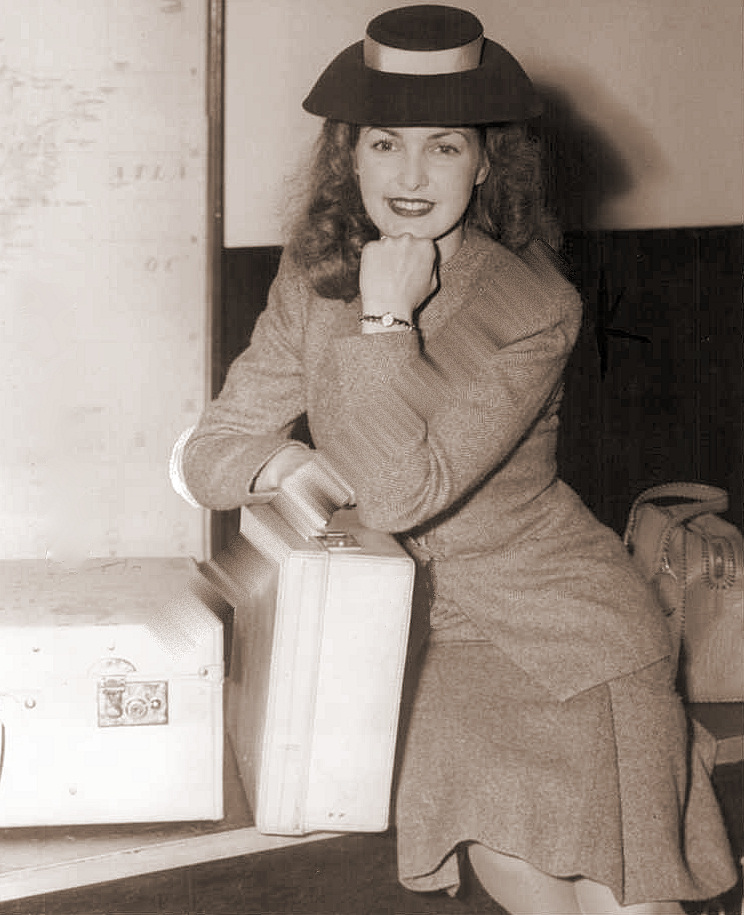 Patricia Roc poses with a couple of suitcases as she waits patiently for customs