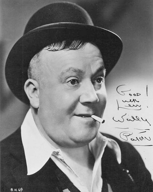 Autographed photo of English actor, Wally Patch (1). The actor wears a bowler hat and open-necked shirt, while a cigarette droops from his mouth